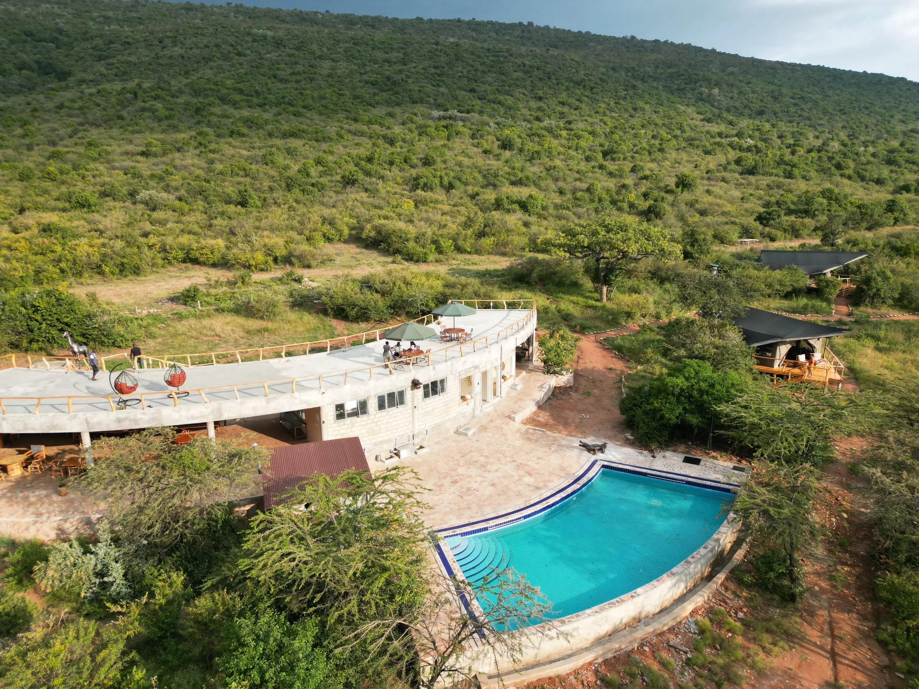 Drone view of the main building, its rooftop deck and the pool